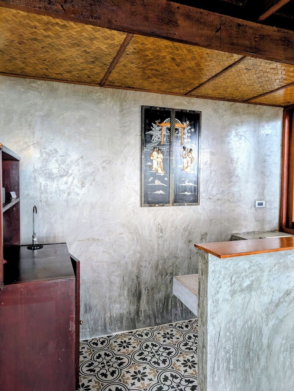 Ein Zimmer mit rustikalem Deckenbalken, einer traditionellen Tür mit Kunstwerk, einer Holzauskładung und einem gemusterten Boden.