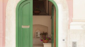 Una puerta verde da acceso a una escalera.