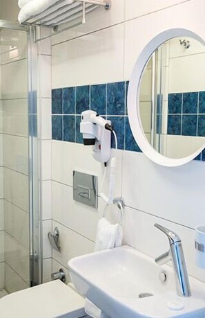 A bathroom with a white sink, a mirror, and a towel rack. - Esinti Hotel (Bozcaada)