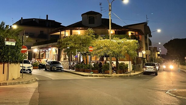 A building with a central courtyard, surrounded by parked cars and street lamps.