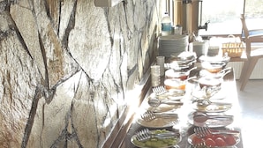 A buffet with various food items and utensils, including fruits, vegetables, and bread. - Geyikli Berfin Otel (Ezine)