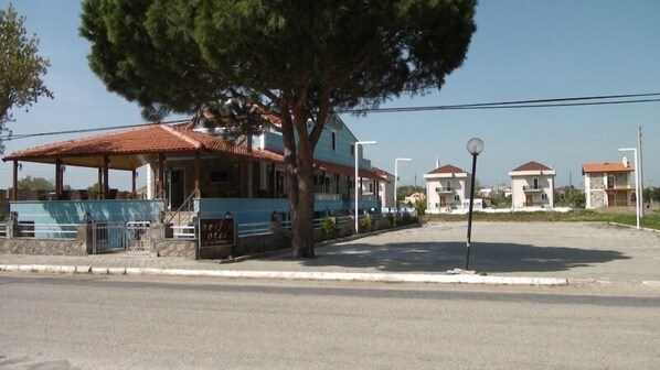 A building with a tiled roof, a covered area with a railing, and a sign that reads "Hotel". - Geyikli Berfin Otel (Ezine)