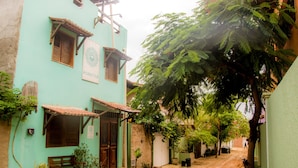 A narrow street with a building featuring a sign that reads "A CASA É SUA". - Pousada A Casa é Sua (Jijoca de Jericoacoara)