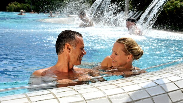 A swimming pool with clear water, a tiled edge, and a water feature in the background. - Haus Roseneck (Bad Bevensen)
