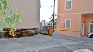 A gated driveway leading to a building with a stone wall and a metal gate. - Electra Syros Boutique Hotel (Syros)