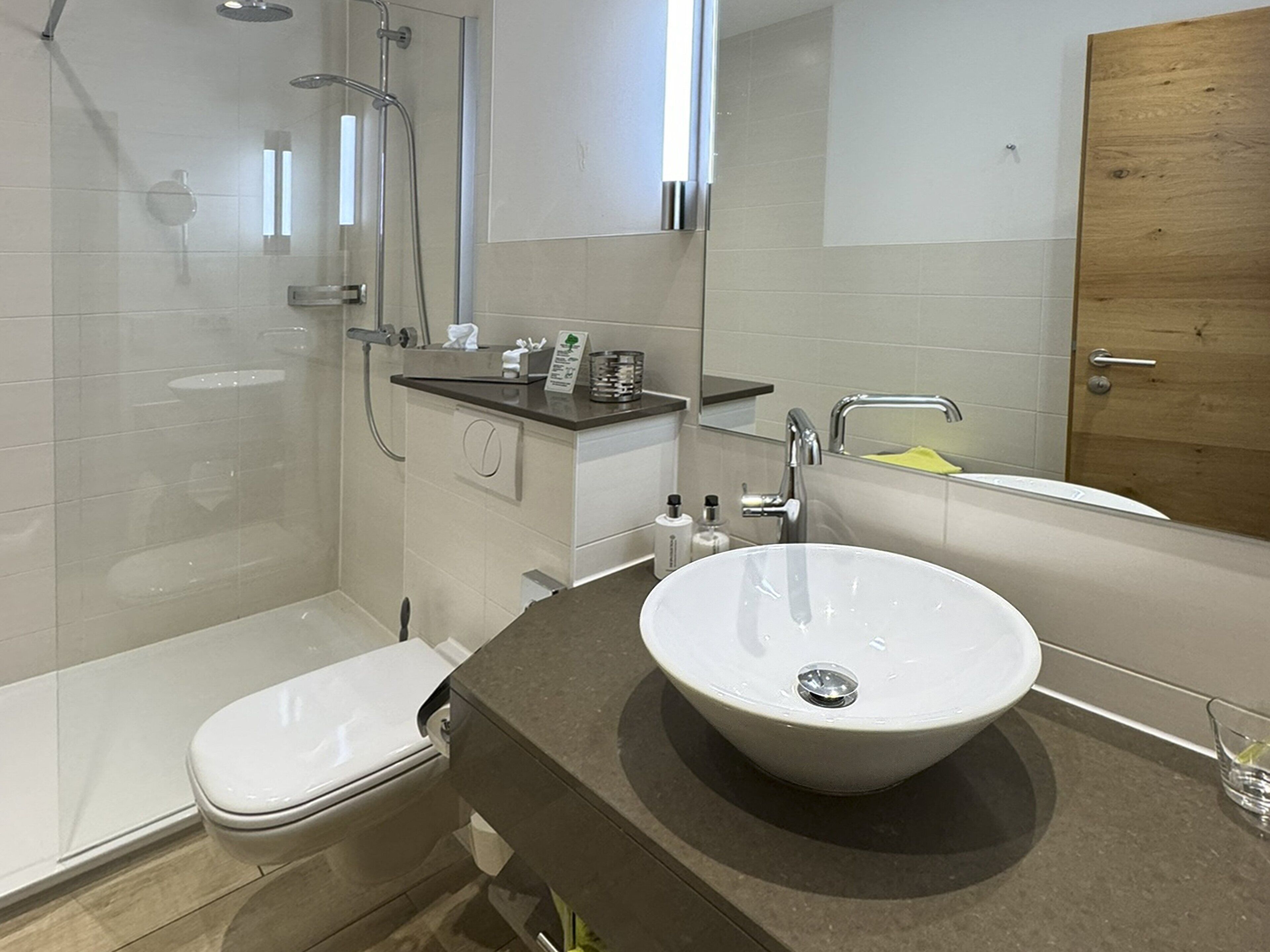 Un baño moderno con ducha, inodoro, lavabo y bañera.