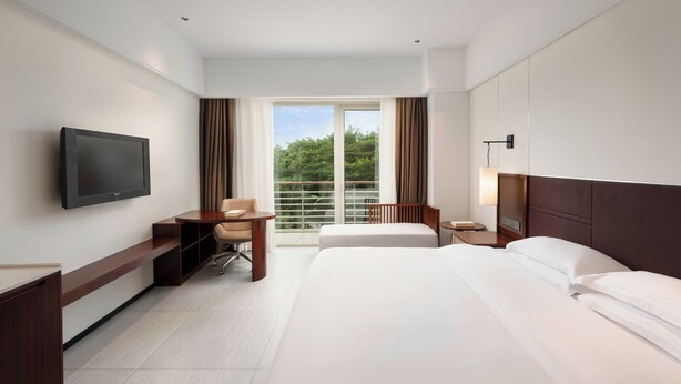A hotel room with a bed, a desk, a chair, a television, and a window with curtains. - Grand Soluxe Hotel And Resort Sanya (Sanya)