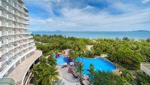 A resort with a swimming pool surrounded by palm trees and a view of the ocean. - Grand Soluxe Hotel And Resort Sanya (Sanya)