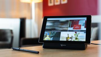 A tablet displaying a hotel website with multiple rooms and amenities.