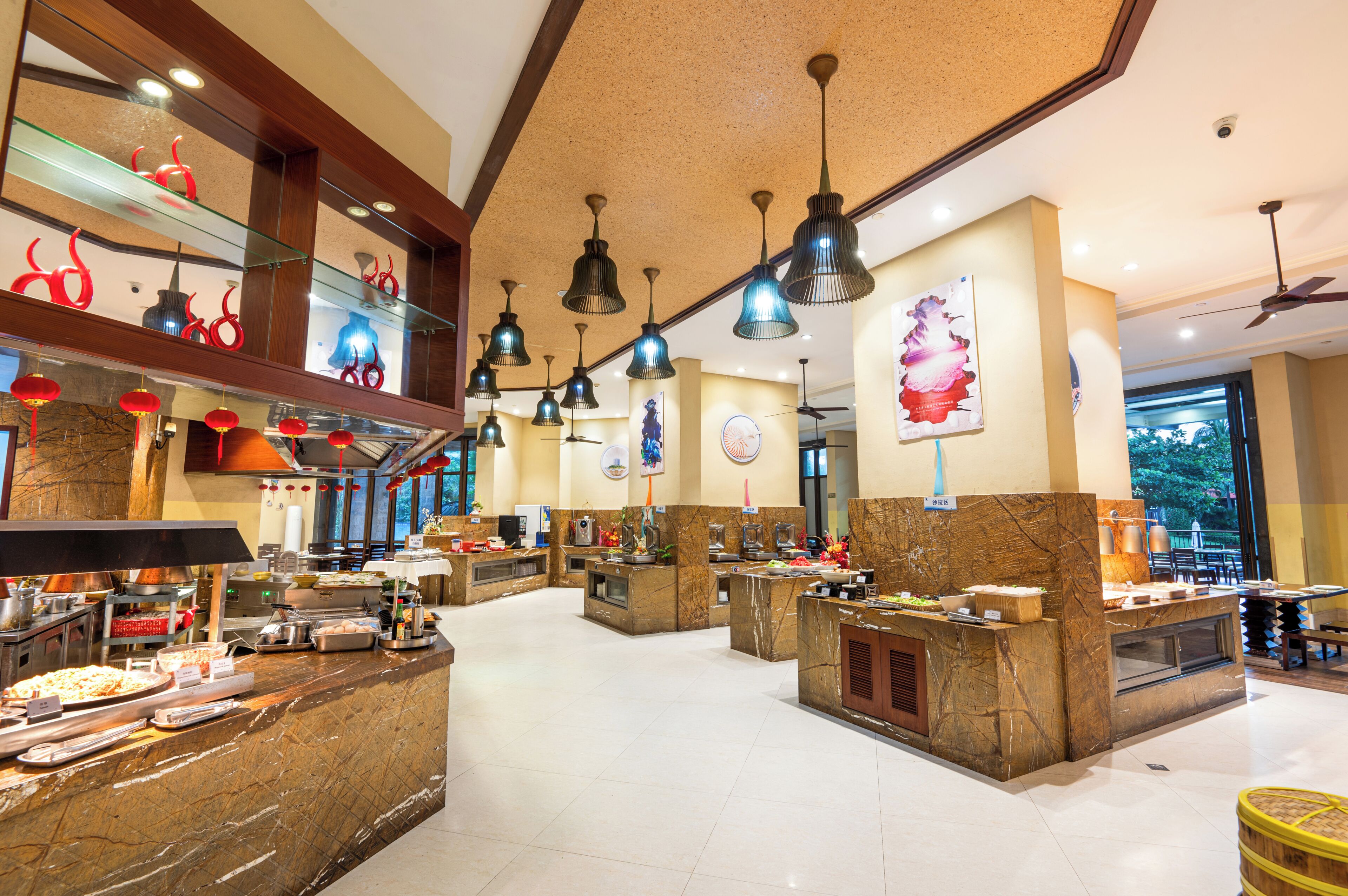 A spacious hotel lobby with multiple dining areas, a reception desk, and a large window offering a view of the outdoors.
