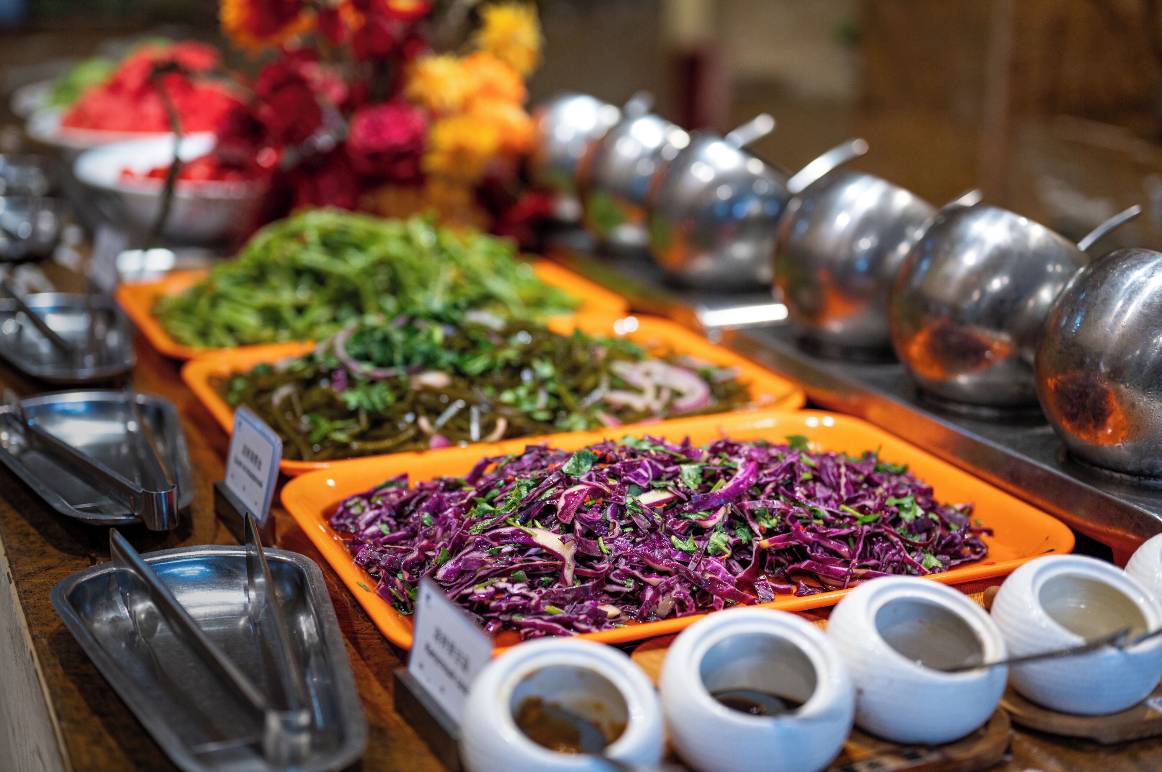 A buffet with various dishes and condiments.