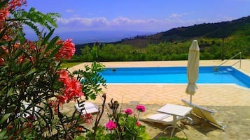 Una piscina al aire libre de temporada, sombrillas