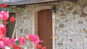 A stone building with a wooden door and a small porch. - Agriturismo San Fele (Cerchiara di Calabria)