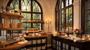 A breakfast buffet with various food items and a candlelit ambiance.