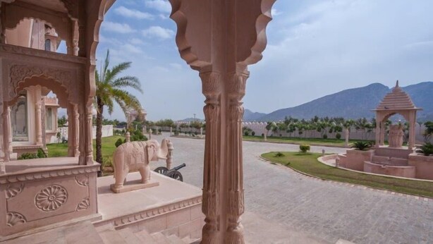 A courtyard with a large elephant statue, a gazebo, and a mountain in the background. - Bhanwar Singh Palace (Pushkar)
