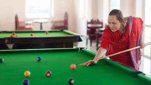 A person playing pool in a room with multiple tables. - Bhanwar Singh Palace (Pushkar)