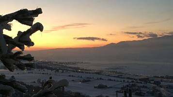 A snowy landscape with a sunset in the background.