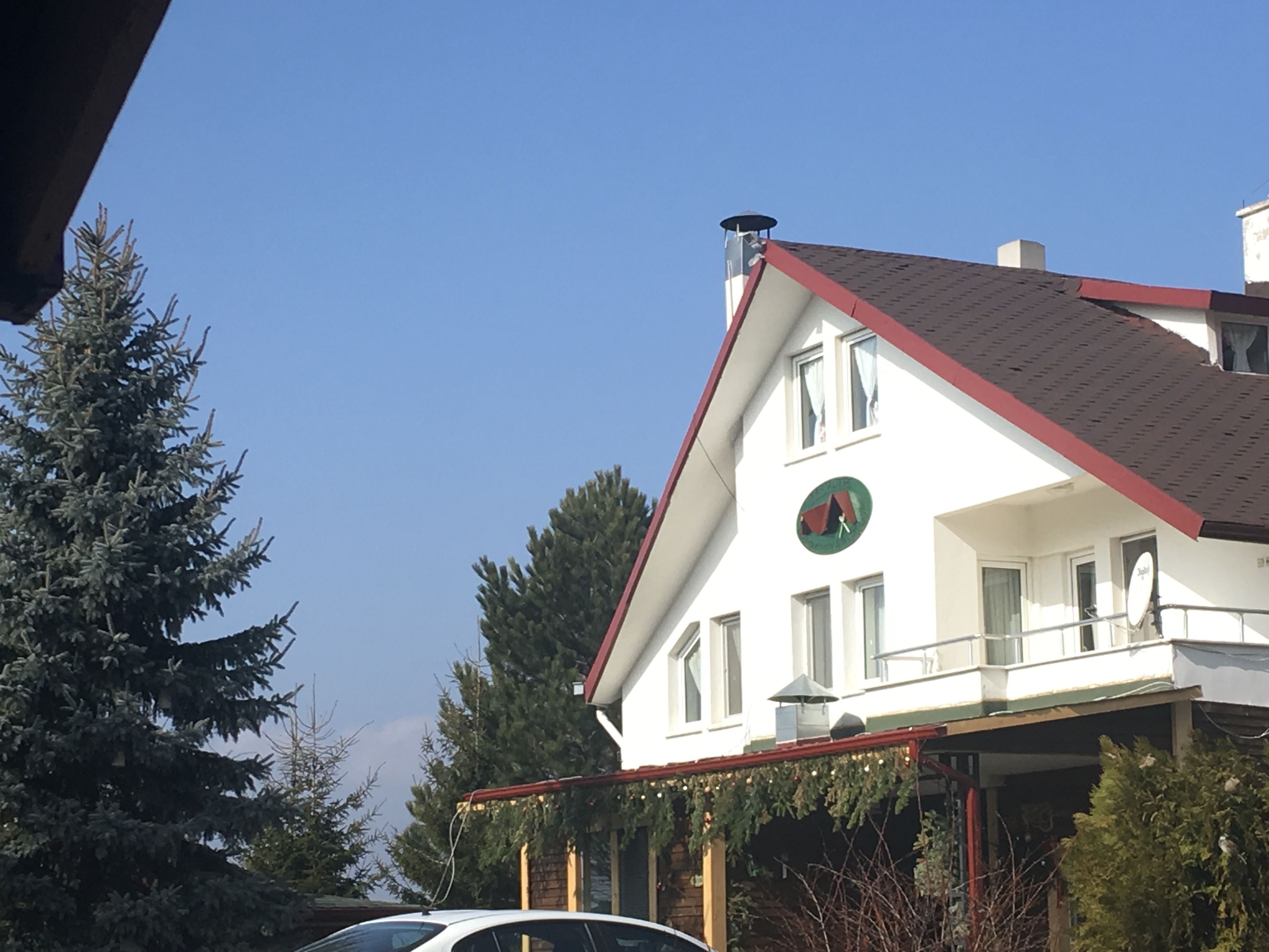 Un edificio de dos pisos con techo rojo y un reloj en la pared frontal.