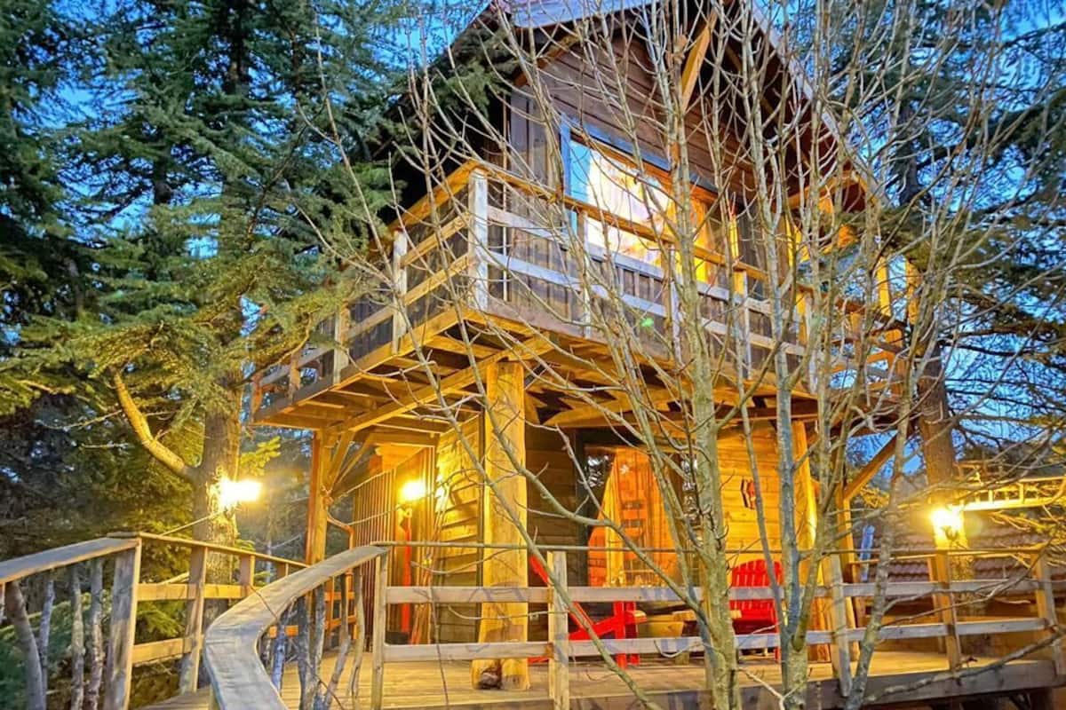 Eine Holzhütte mit einer Holzterrasse und einer Treppe zum Eingang.
