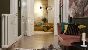 Et værelse med et zebra-tæppe, en sofa med puder, en radiator og en plante på væggen.
