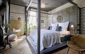 Un dormitorio moderno con una cama grande, un espejo redondo y una araña.