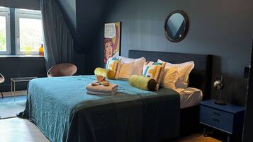 A bedroom with a bed, bedside table, and a window.