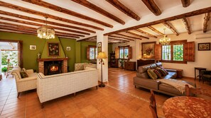 Amplia sala de estar con chimenea, sofás y comedor.