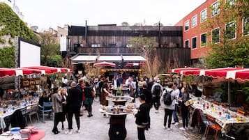 Evento al aire libre con varias mesas y personas.