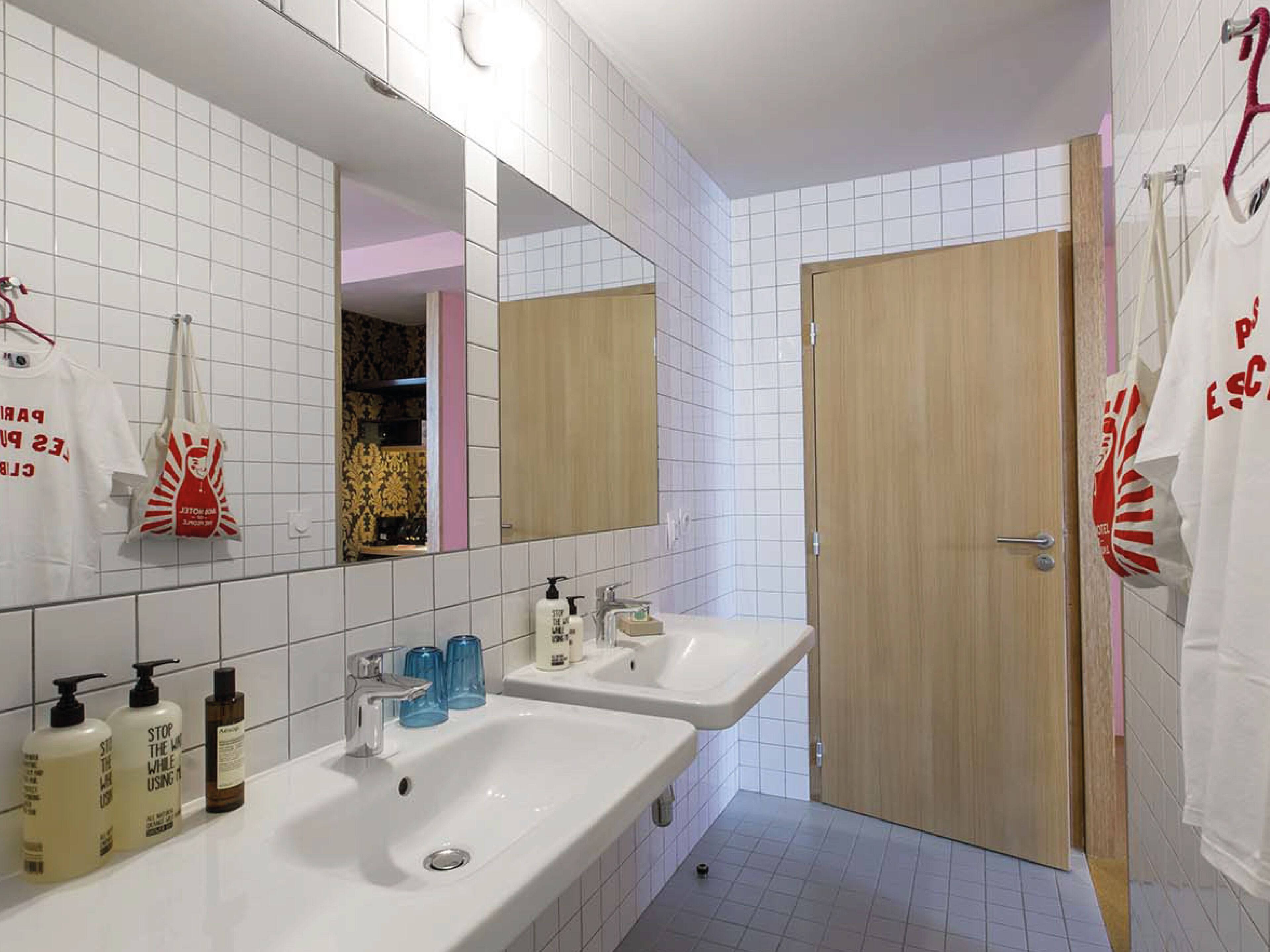 Un baño moderno con dos lavamanos, un espejo y una zona de ducha.