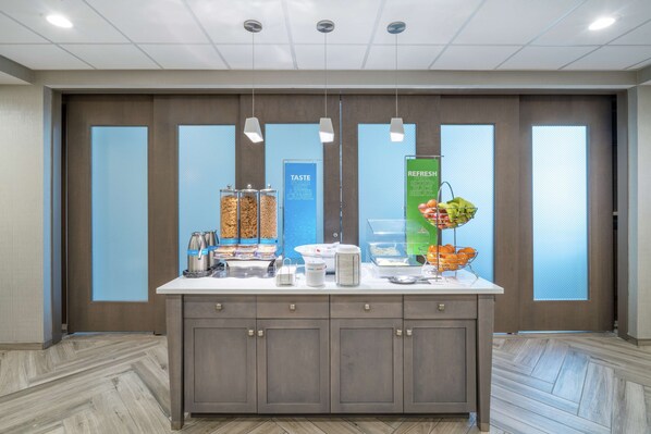 A buffet setup with various food items and a beverage station. - Hampton Inn & Suites Glenarden/Washington DC (Lanham)
