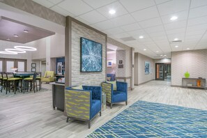 A hotel lobby with seating areas, a reception desk, and a large abstract painting on the wall. - Hampton Inn & Suites Glenarden/Washington DC (Lanham)