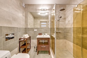 Appartement | Badkamer | Een douche, gratis toiletartikelen, een haardroger, handdoeken