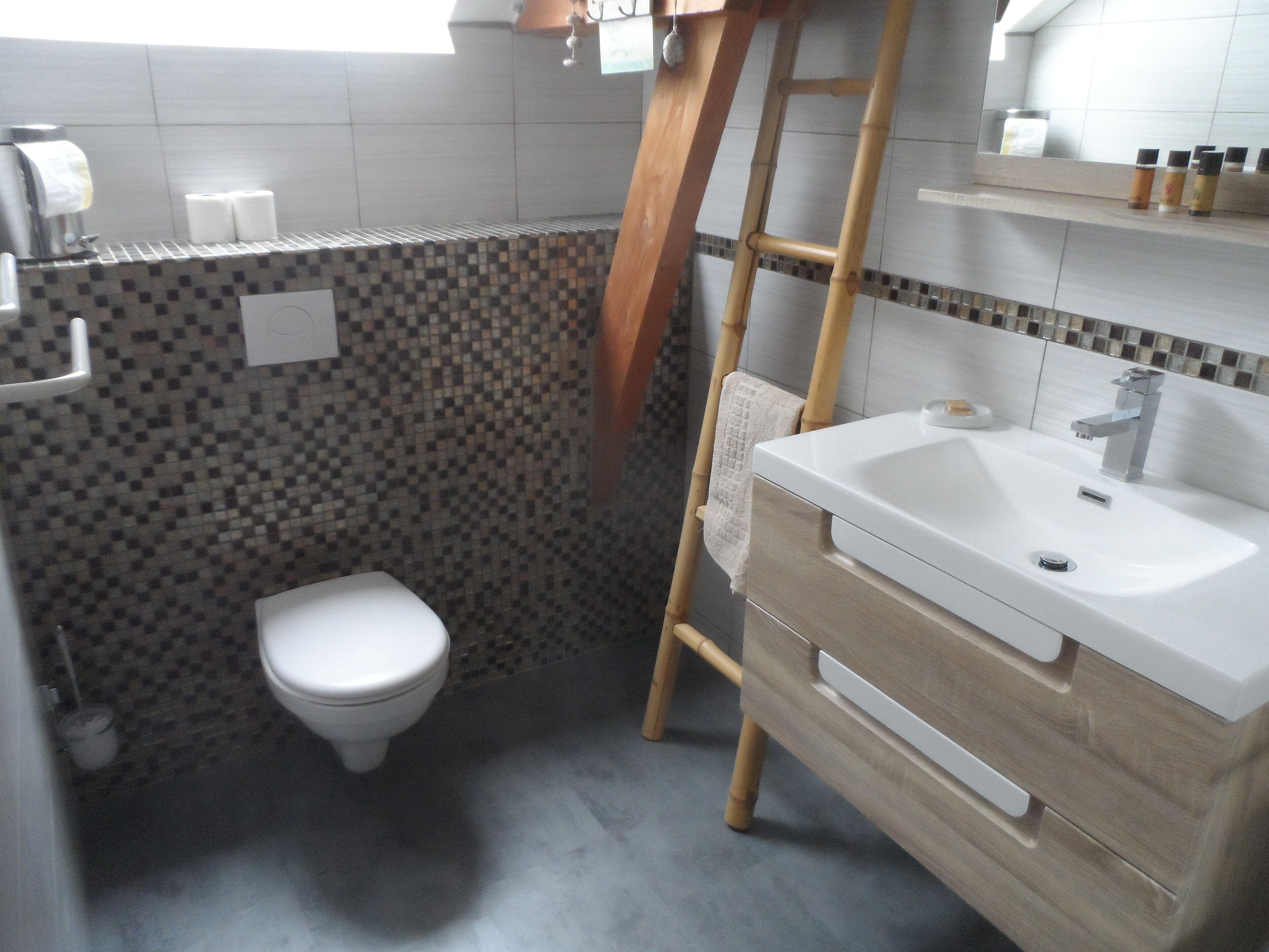 A bathroom with a toilet, a sink, and a shower area.