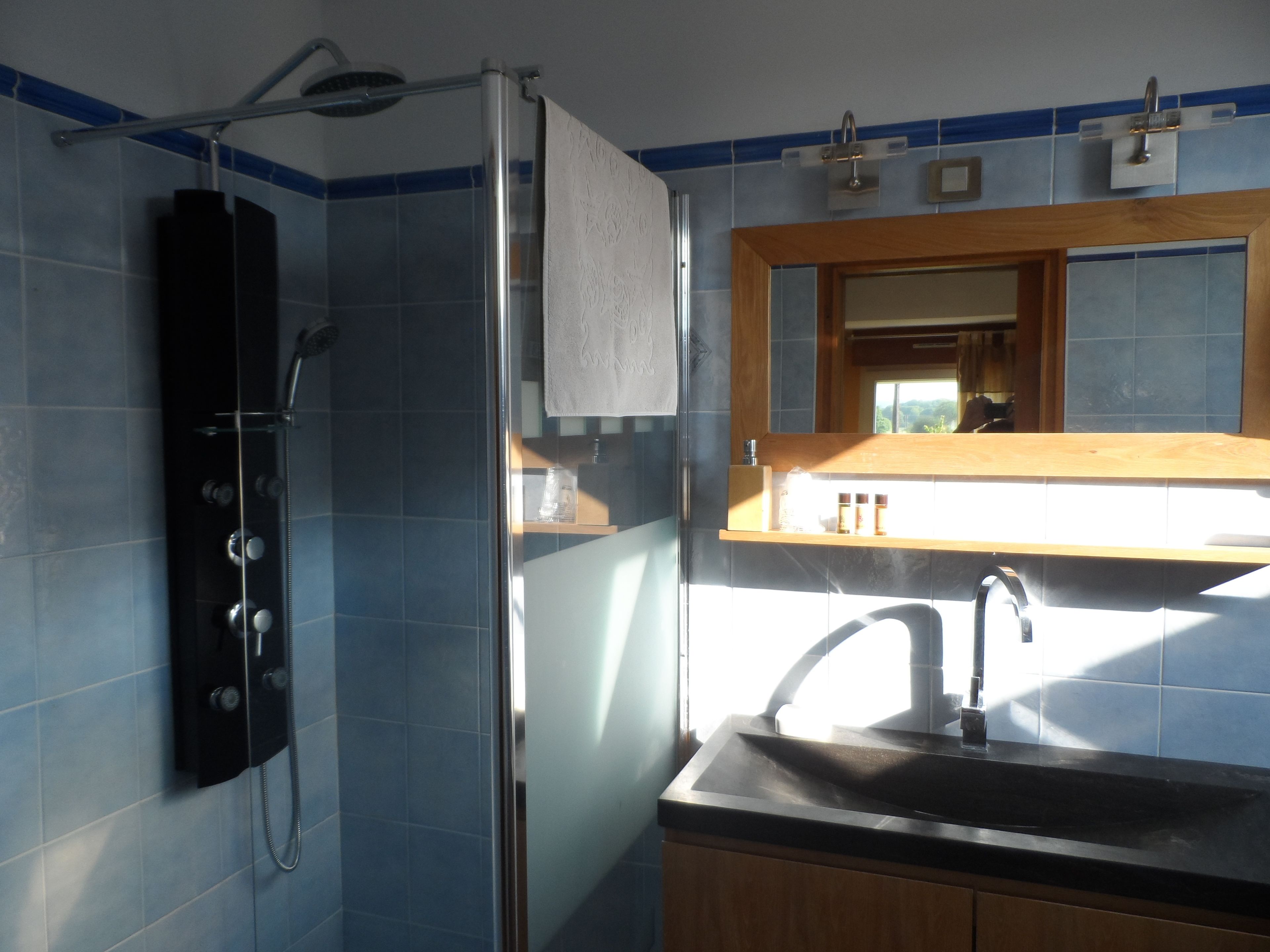 Ein Badezimmer mit Dusche, Waschbecken und Holzschränken.