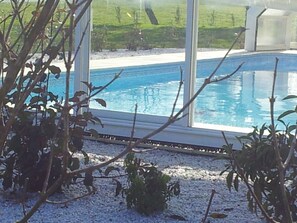 Una piscina techada, sillones reclinables de piscina