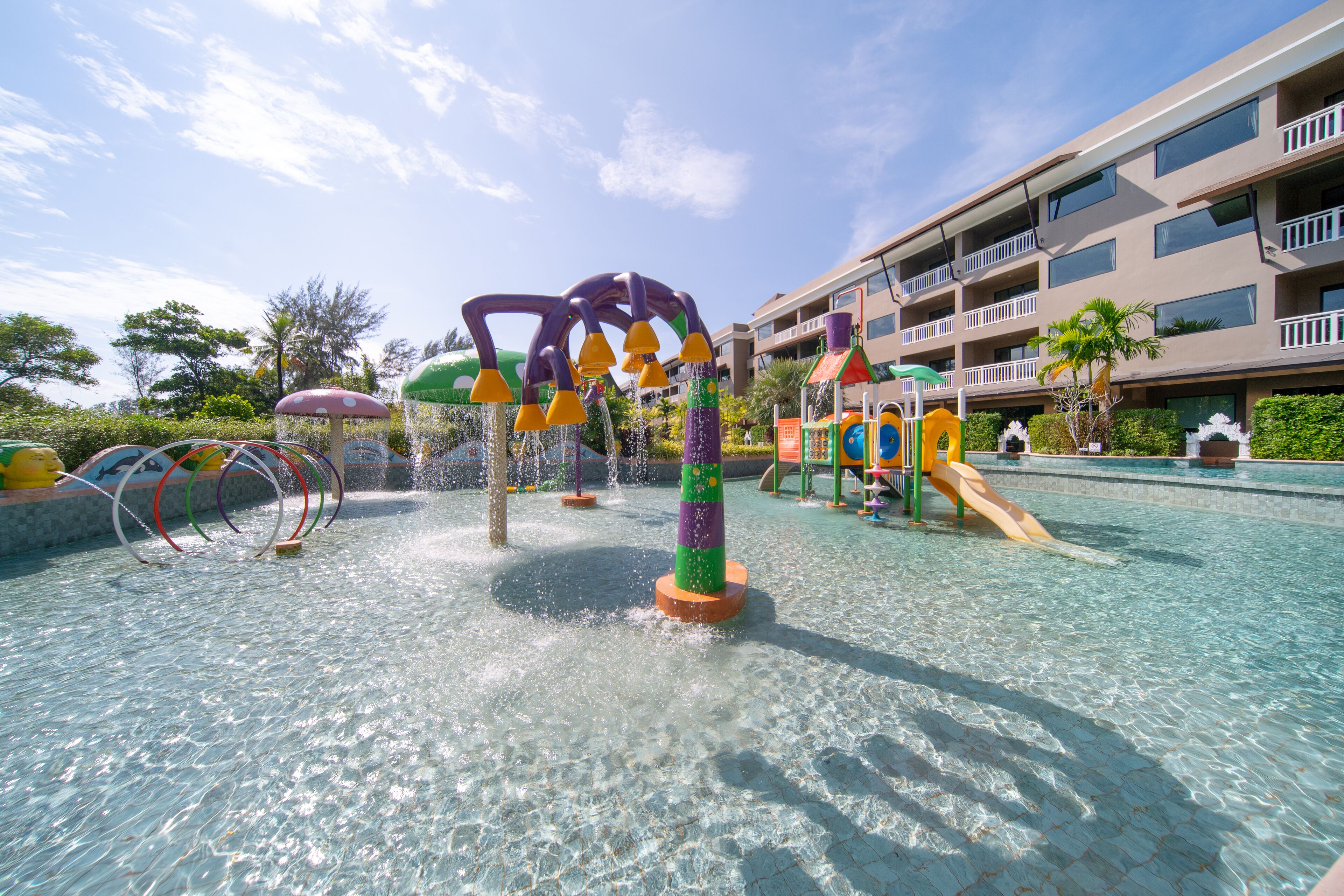 Un espacio de juegos acuáticos con estructuras coloridas y una piscina.
