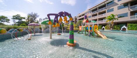 Un espacio de juegos acuáticos con estructuras coloridas y una piscina.