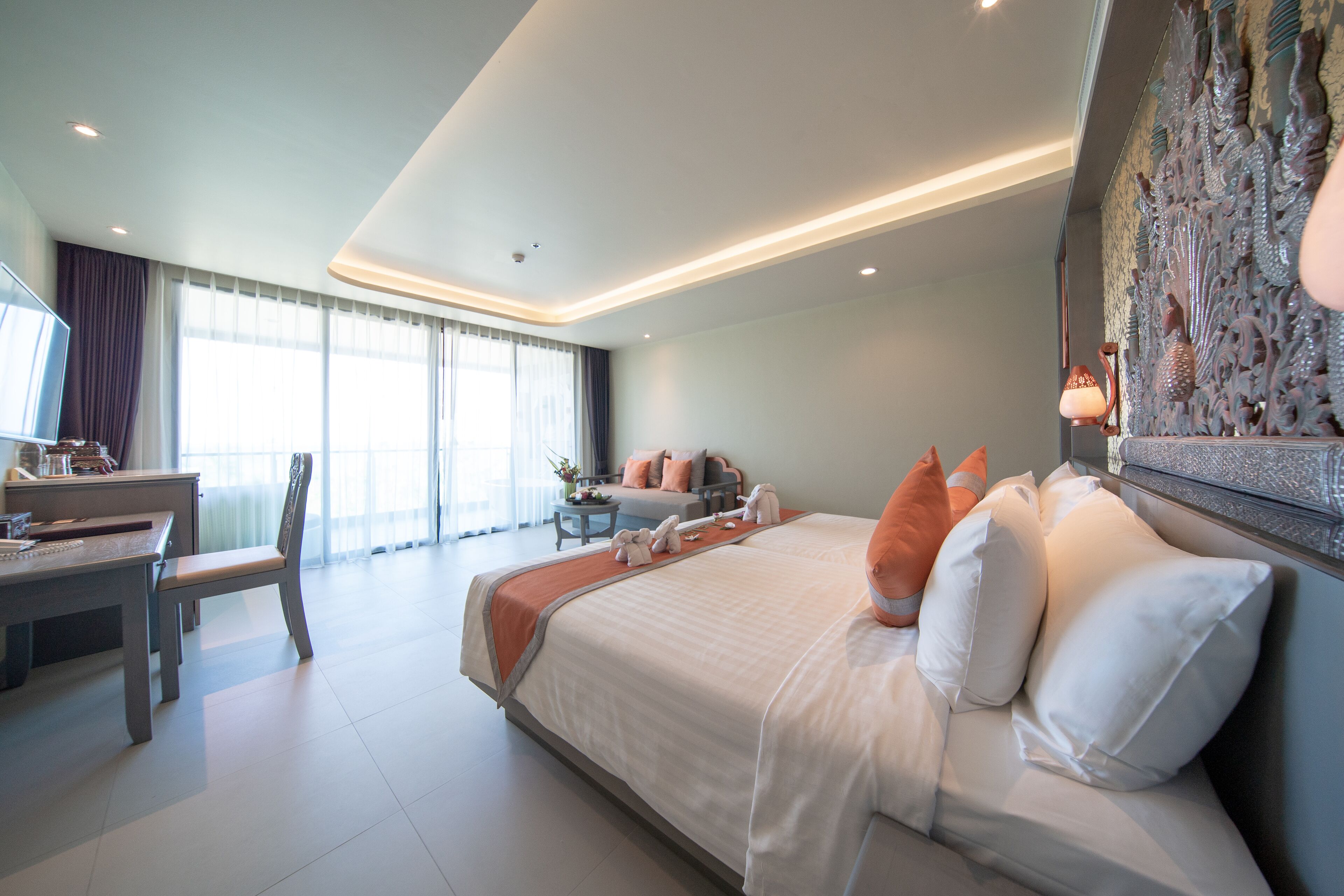 Quarto de hotel moderno com uma cama grande, uma escrivaninha e uma cadeira.