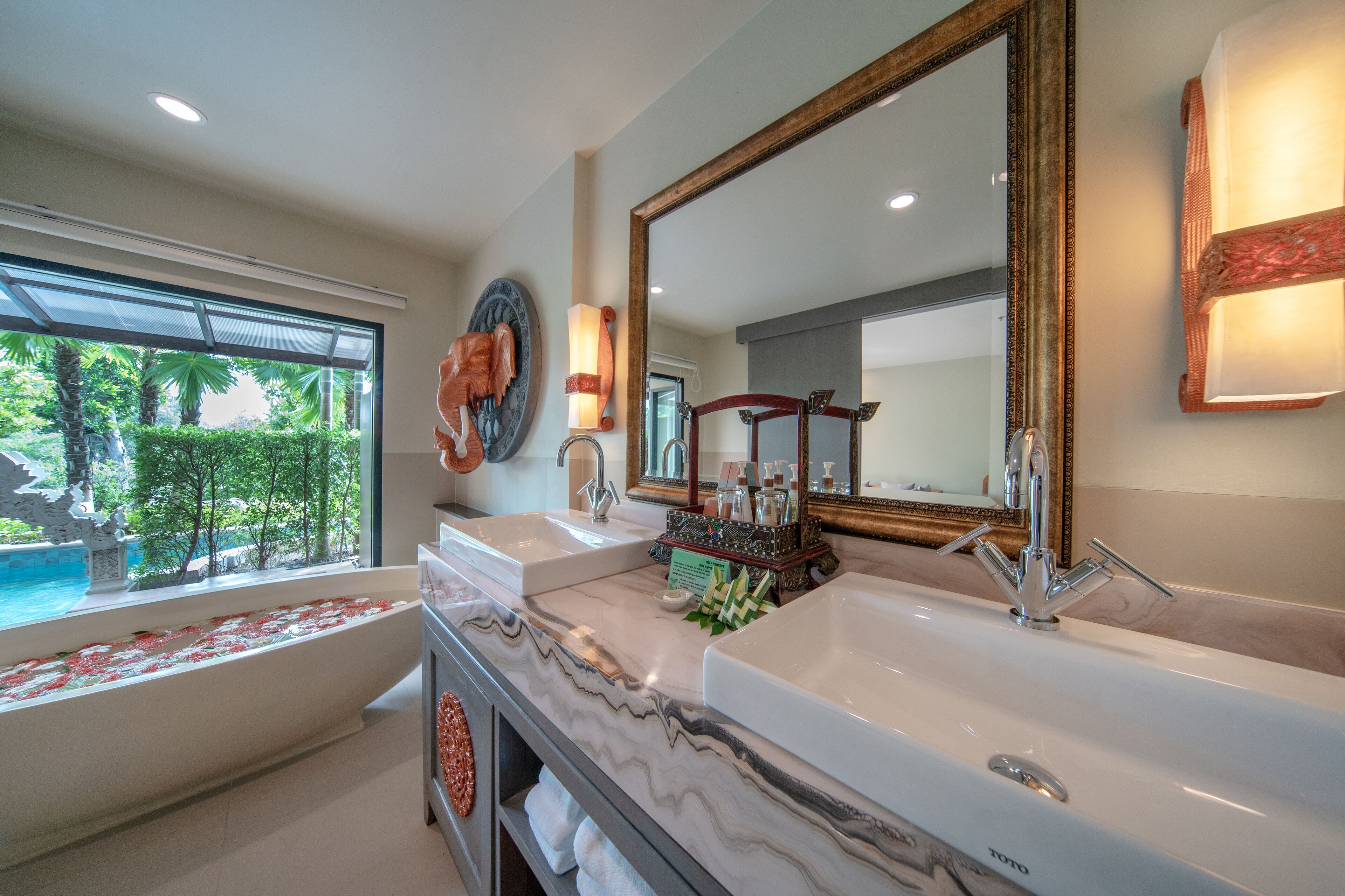 A bathroom with two sinks, a bathtub, and a large mirror.