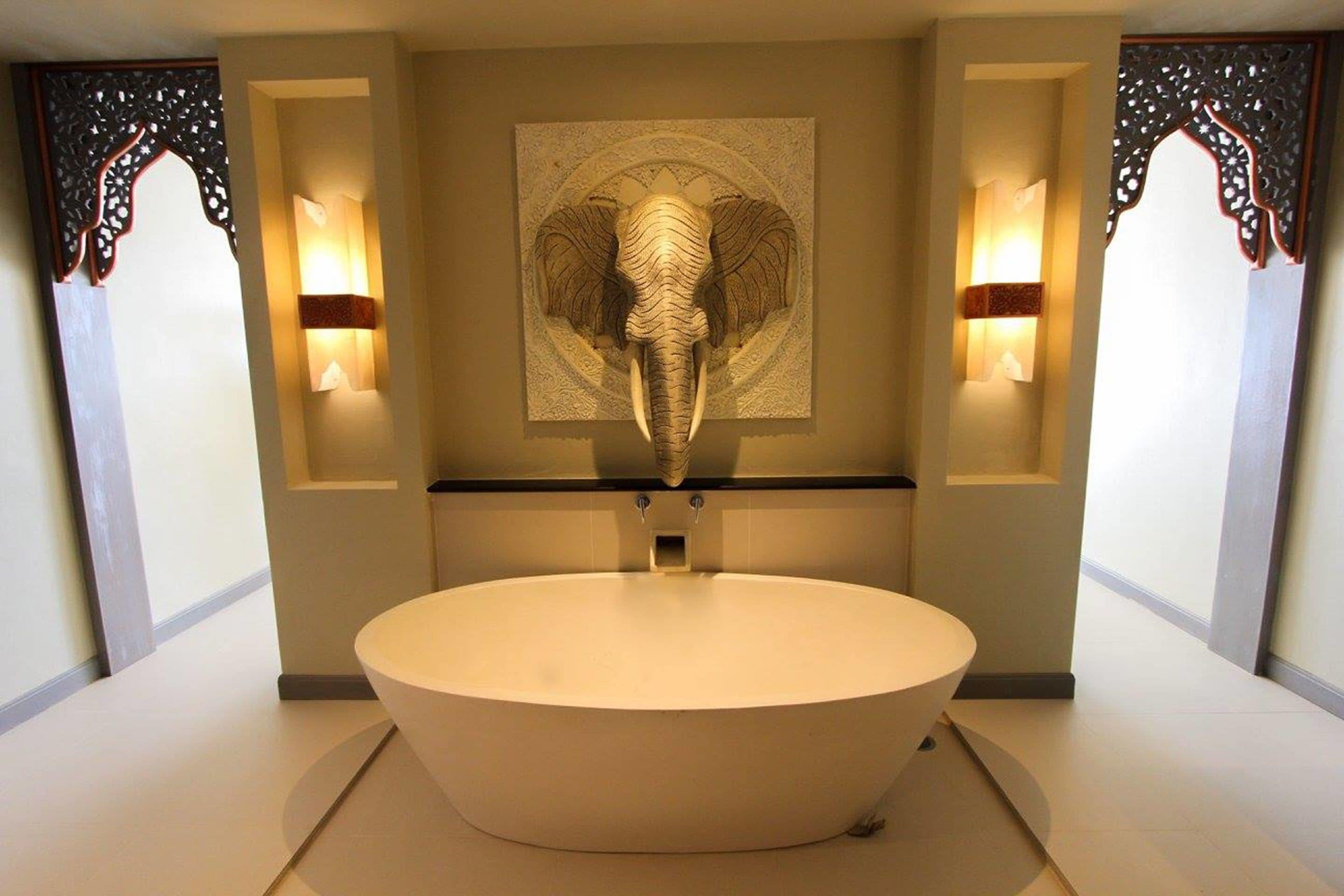 Un baño moderno con un lavabo ovalado grande, paneles decorativos en la pared e iluminación empotrada.