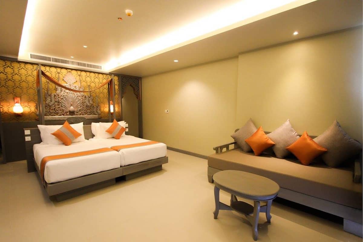 Quarto de hotel moderno com uma cama grande, um sofá e uma mesinha.