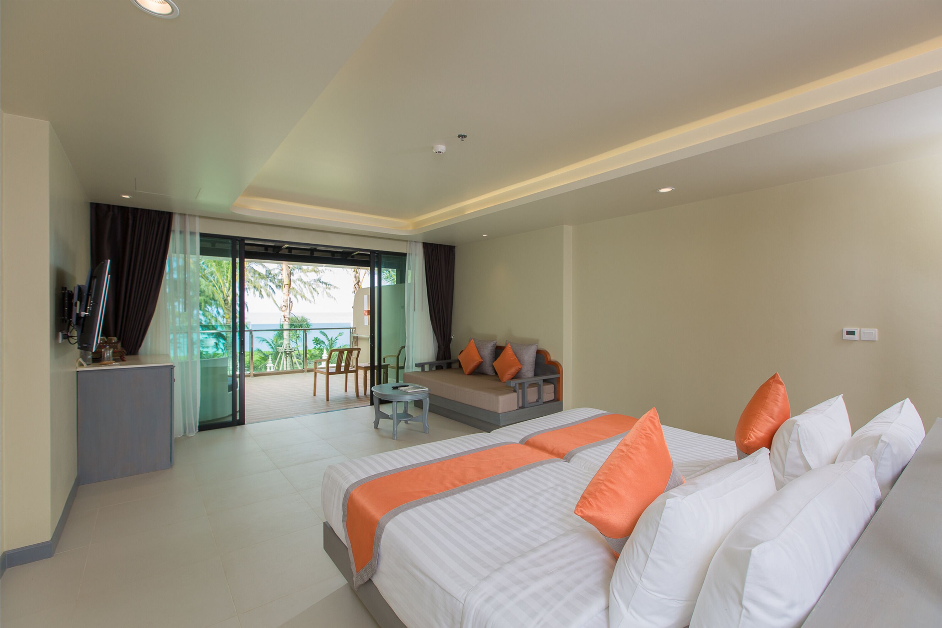A hotel room with a large bed, a desk, and a balcony with a view.
