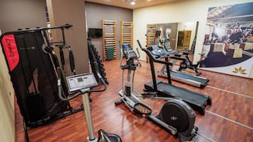 A gym with various exercise equipment including treadmills, an elliptical, and a weight machine.
