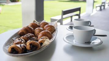 Ein Tisch mit einem Teller Croissants und einer Kaffeetasse.
