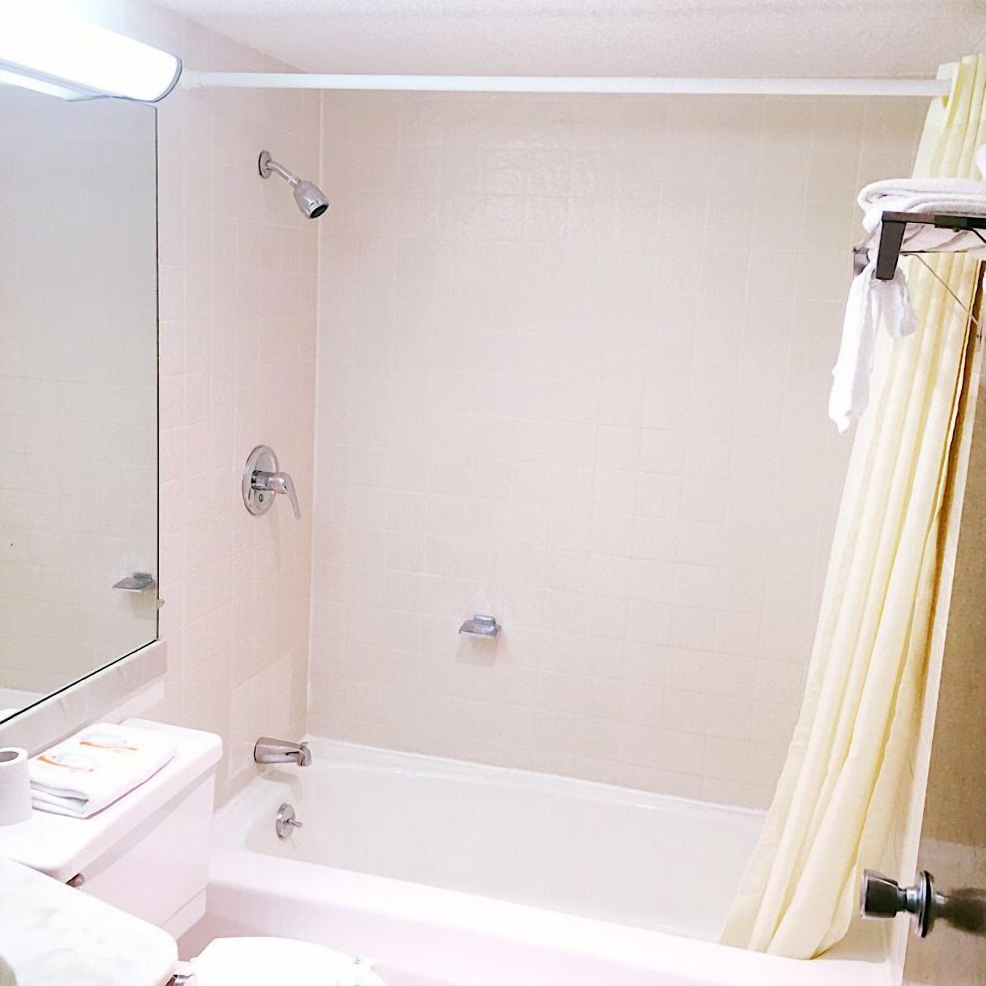 A bathroom with a bathtub, a toilet, and a sink.