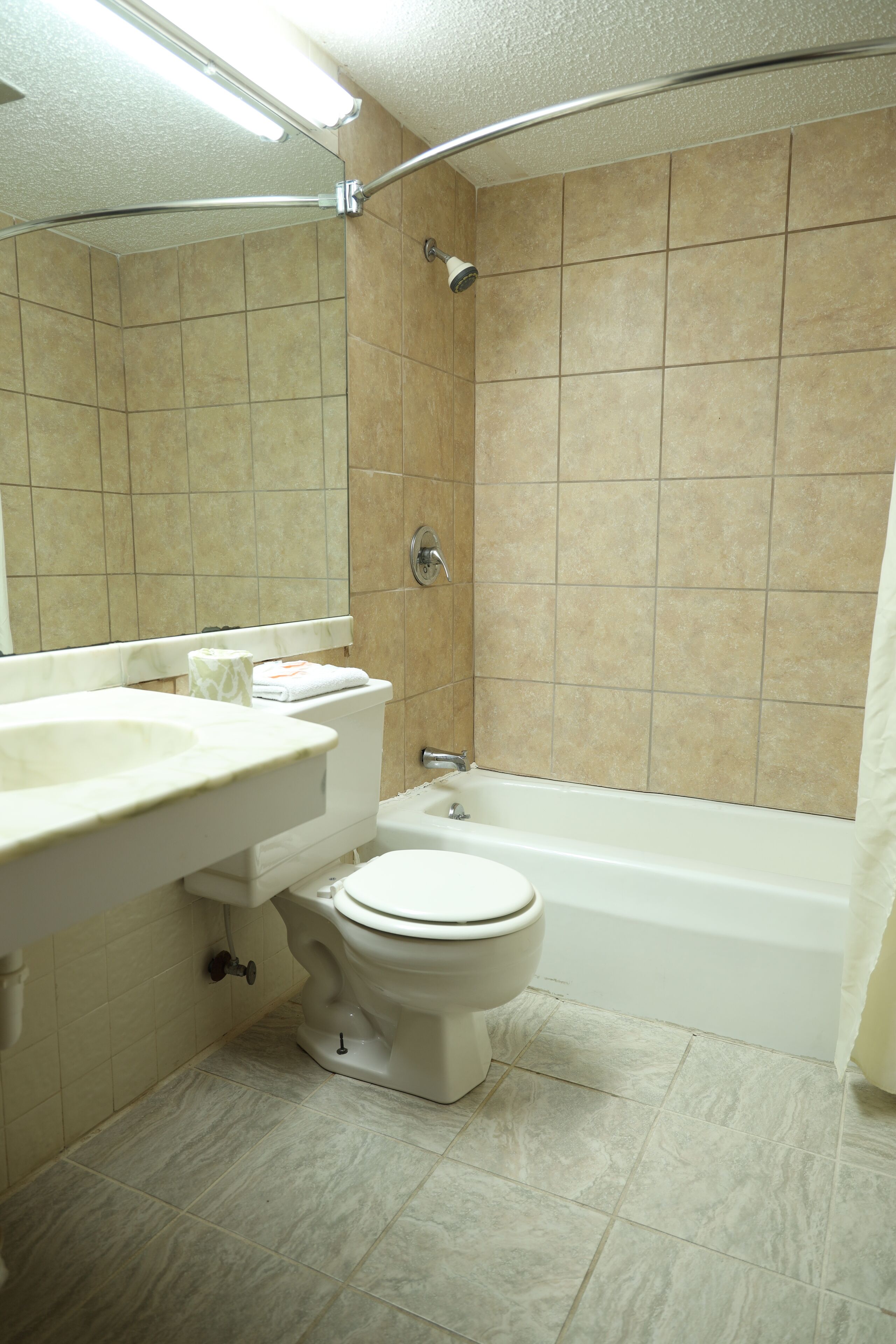 A bathroom with a toilet, sink, and bathtub.