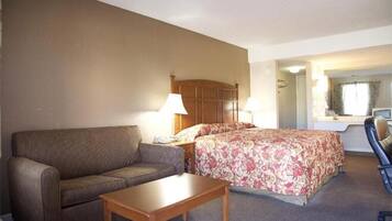 A hotel room with a bed, a sofa, a desk, and a chair.