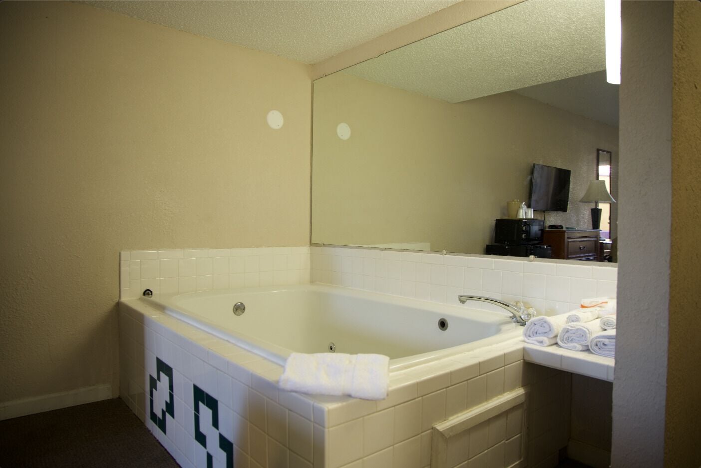 A standard hotel bathroom with a bathtub, a sink, and a mirror.