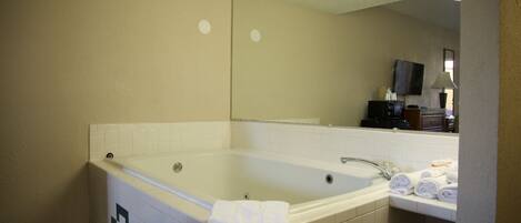A standard hotel bathroom with a bathtub, a sink, and a mirror.