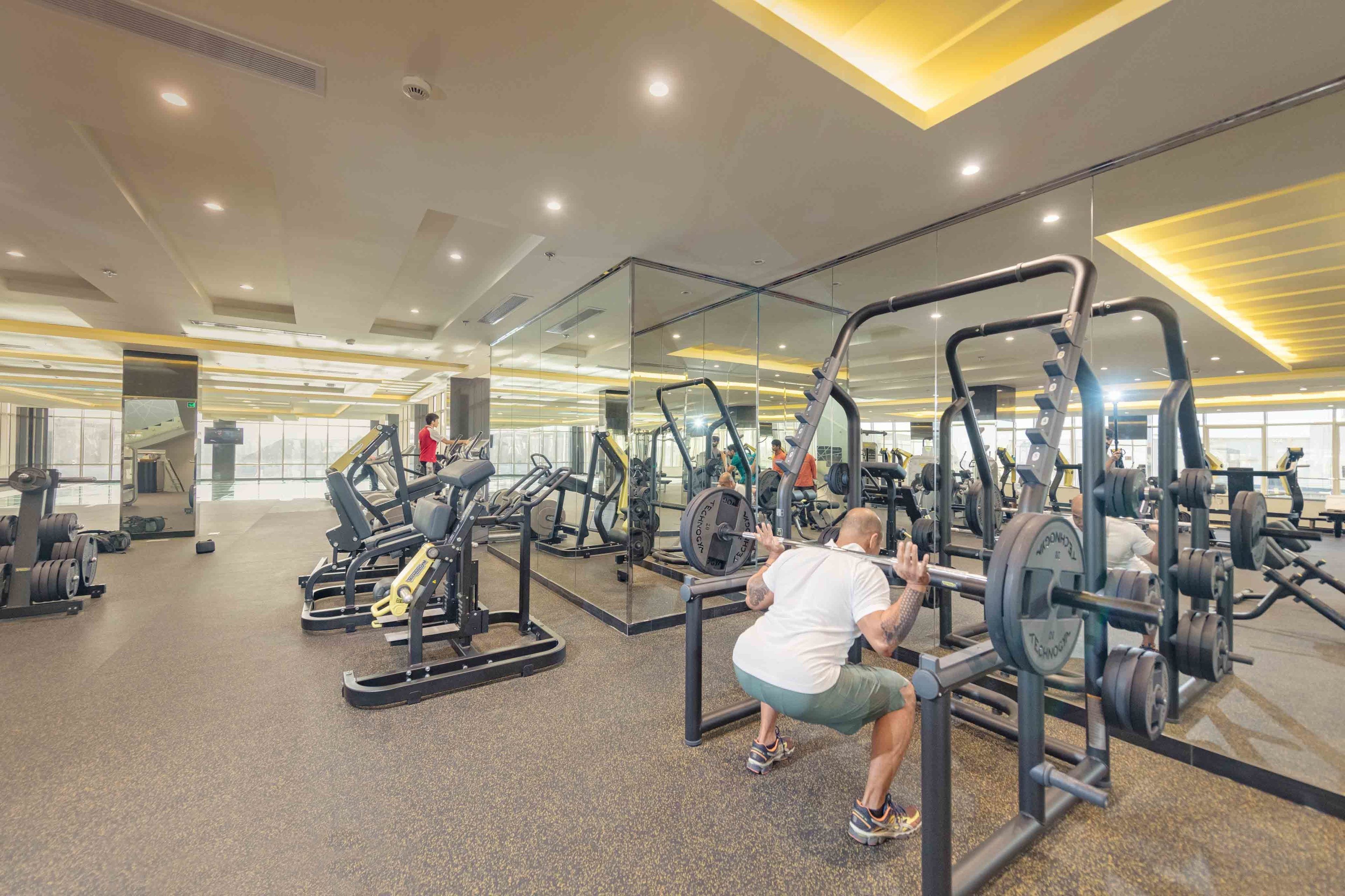 A gym with various exercise equipment, including weight machines and free weights.